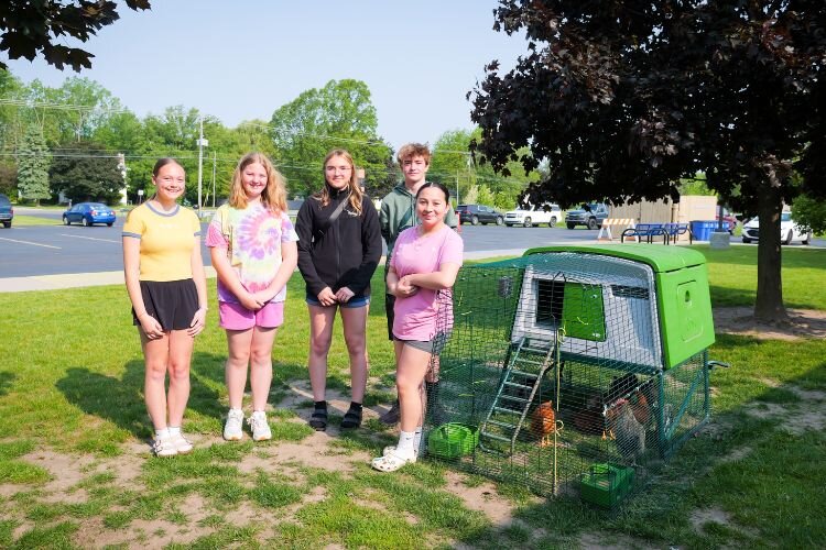 Five members of Renaissance’s Chicken Tenders club pose outside one of their school’s chicken coops.