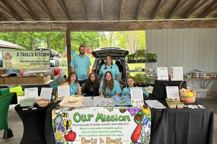 Blake Buzard, Rachel Brandeberry, and Renaissance students represent Roots ‘n Roost at their first Mt. Pleasant Farmers’ Market on Thursday, May 29, 2025.
