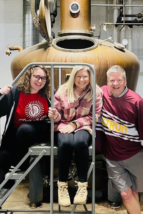 Detroit City Distillery employees and CMU RPL grads Amelia Givens and Alyssa Young sit with Tim Otteman. Photo Credit: Courtesy Tim Otteman