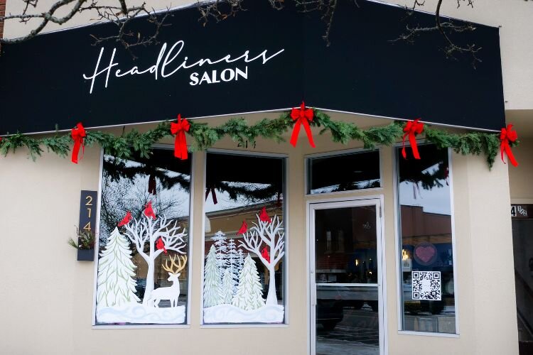 A winter wooded wonderland with cardinals is painted on the windows of Headliners Salon on Broadway Street in downtown Mt. Pleasant by artist Sara Woodruff. Photo Credit: Courtney Jerome / Epicenter Mt. Pleasant
