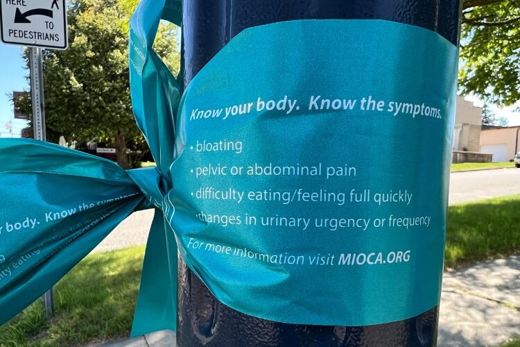 Teal ribbons listing ovarian cancer symptoms and resources are tied on lamp posts in Michigan downtowns during the annual Tie Michigan Teal campaign every September. (Courtney Jerome / Epicenter Mt. Pleasant)