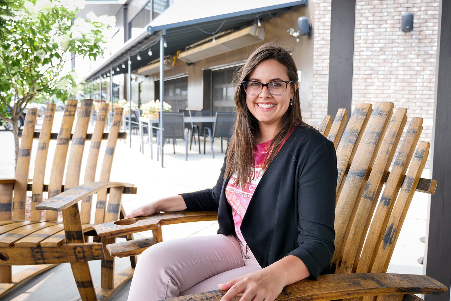 Kash Meisheri relaxes in wood chairs made by Mug Club member Joe McDonald at Summit Smokehouse & Tap Room's recently updated outdoor seating area. (Photo: Courtney Jerome/Epicenter)