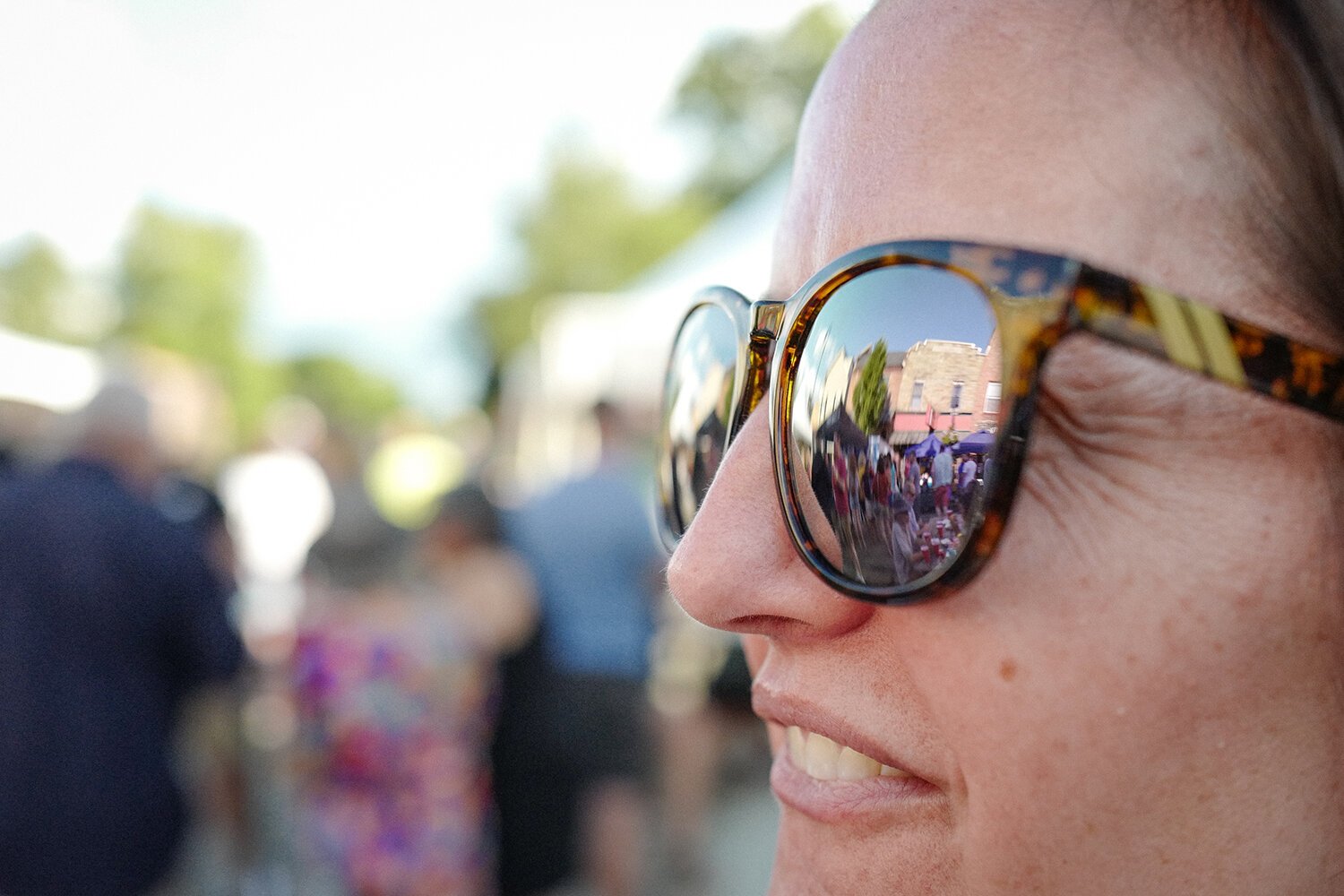 Mt. Pleasant woman Erica Peters enjoys the action on Main Street; the reflection in her glasses depicts the Bird Bar and Grill in Mt. Pleasant, MI on Saturday, July 29, 2023. (Photo: Dan Gaken/Epicenter)