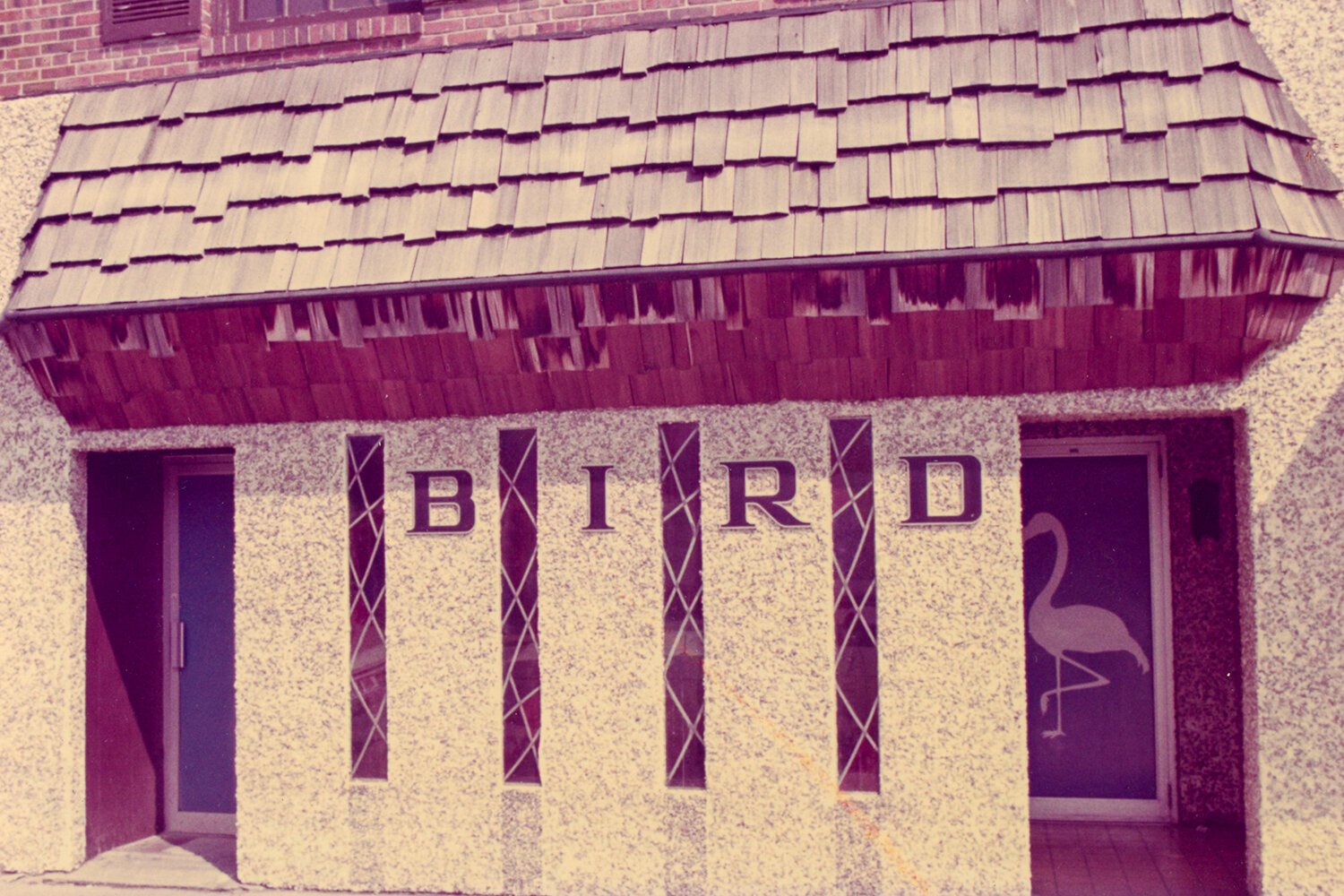 The original façade of 223 South Main St., now The Bird Bar and Grill. For many years this image was featured on postcards of the bar. The reverse of the card read: “Home of the Original Thursday Happy Hour.” Two of the stained glass windows were damaged when the building was renovated, but the Breidenstein Family retains the remaining two. (Undated photo courtesy of the Breidenstein Family)