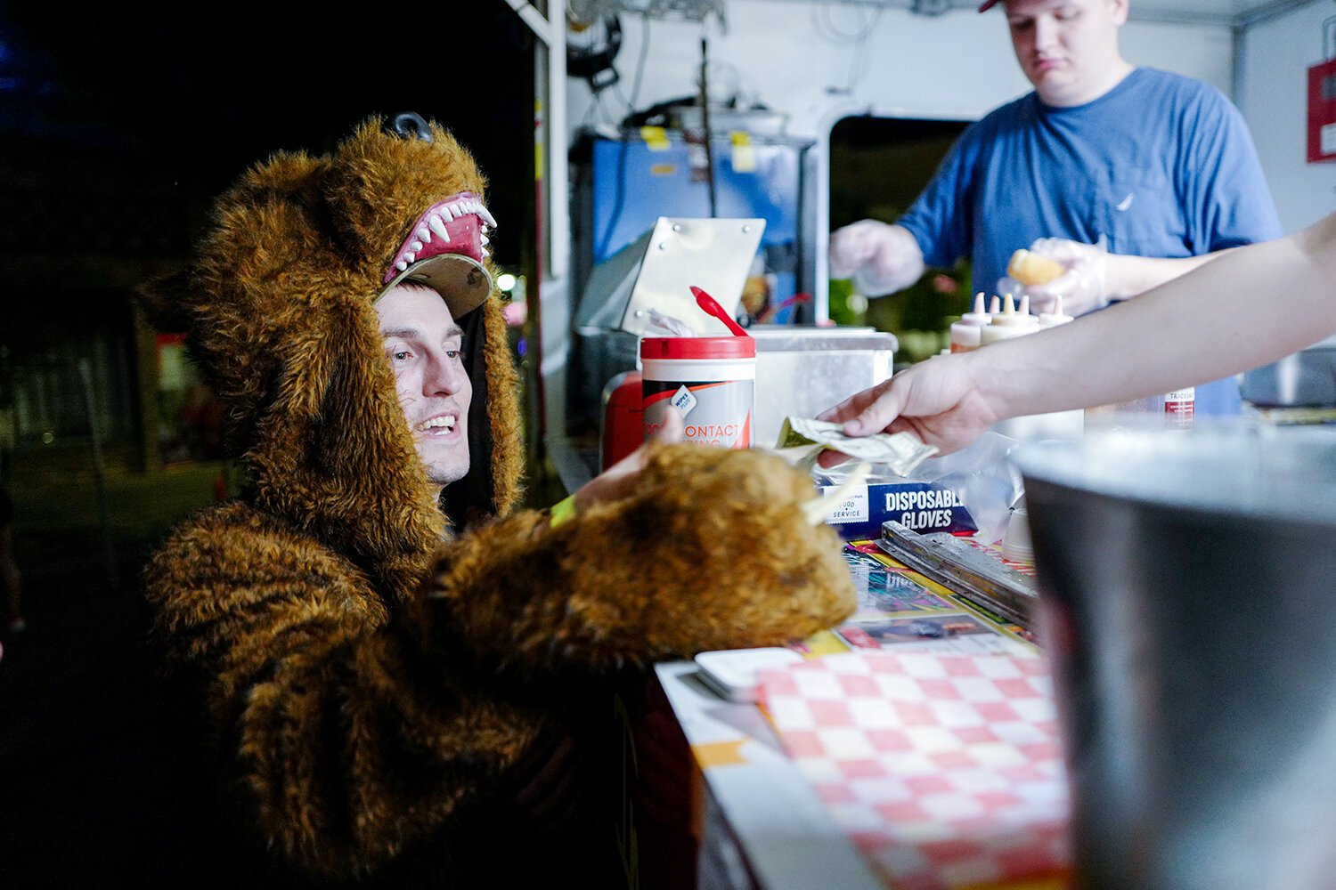 A local man wearing a grizzly bear outfit orders from the Dog Central food truck at the 90th anniversary of The Bird Bar and Grill in Mt. Pleasant, MI. (Photo: Dan Gaken/Epicenter)