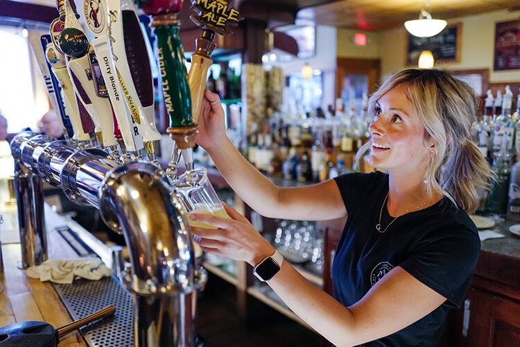 Bartender Grace pours a pint of Maple Ale for a customer at the Shepherd Bar & Restaurant in Shepherd, MI Friday, April 28, 2023.  The maple beer is brewed exclusively for the bar by Four Leaf Brewing in Clare, MI as was released for the annual Maple Syrup Festival. (Photo: Dan Gaken/Epicenter)