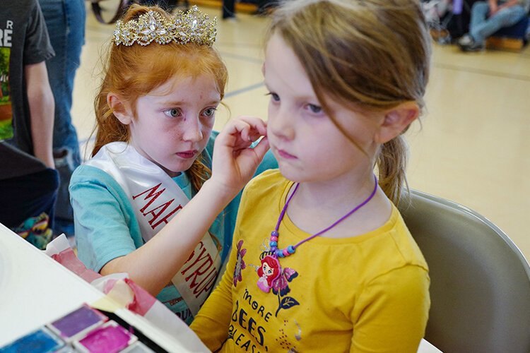 Emma, age 8 of St. Louis, MI applies face paint to a guest at the Children’s Village in the Shepherd Elementary Gym in Shepherd, MI on Saturday, April 29, 2023. (Photo: Dan Gaken/Epicenter)