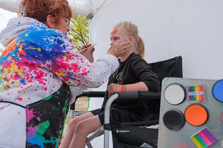 Kaia (age 6) of Rockford, MI has face paint applied by a vendor along Wright Avenue in Shepherd, MI during the annual Maple Syrup Festival on Saturday, April 29, 2023. (Dan Gaken/Epicenter)