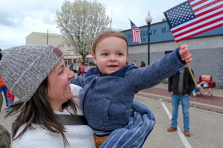 Elias (age 1) of Mt. Pleasant, MI waves an American flag at the Maple Syrup Festival Parade in Shepherd, MI on Sunday, April 30, 2023. (Photo: Dan Gaken/Epicenter)