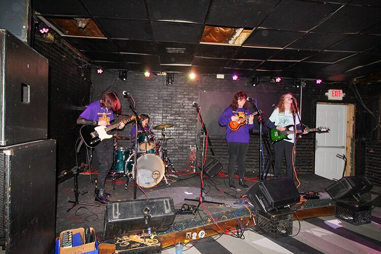 Torrential Reign band members Christina Schafer (drums), Shirley Clifford (black guitar), Rosie Moyer (ukulele), Torren Robinson (green guitar), and bassist Ben Straus (absent) perform at Rubble's Bar in downtown Mt. Pleasant April 2023. (Photo courtesy of Donna Ronan)