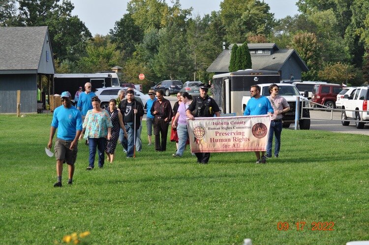 Mt. Pleasant Police Officer VanDyke and County Commissioner Steve Swaney carried the banner that lead the Peace Walk through Island Park during the 2022 event.(Photo courtesy of the Isabella County Human Rights Committee)