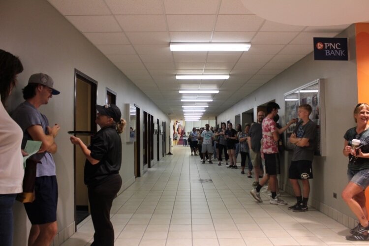 CMU students line up on for student ID photos and receive some free samples of an energy drink while they wait. 