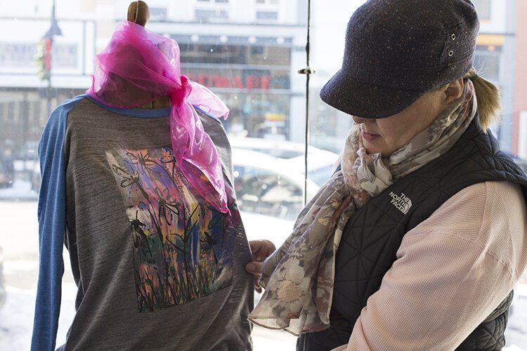 January's featured artist Rebecca Hamilton, of Oh My Soul Art, sets up her window display at For Arts Sake.