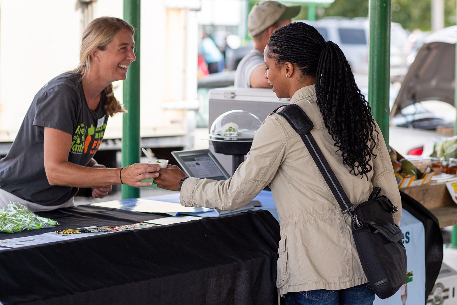 A Farmers Market Food Navigator interacts with a market patron.