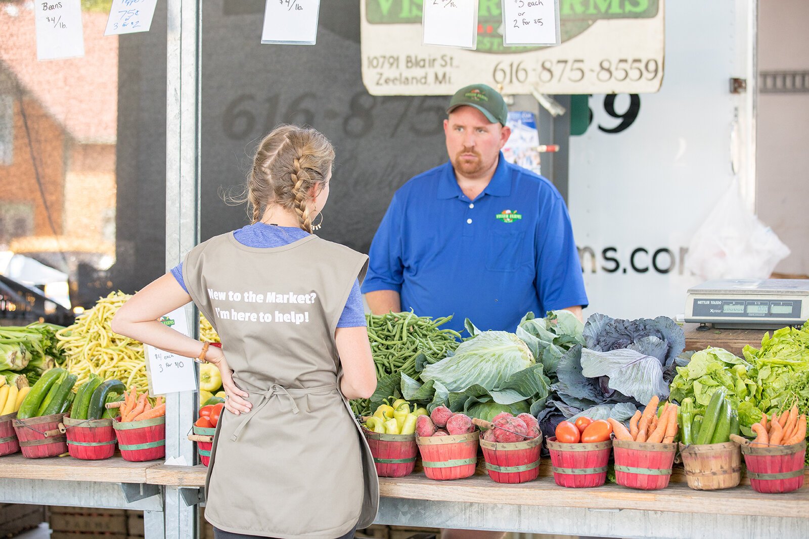 A Farmers Market Food Navigator interacts with a market patron.