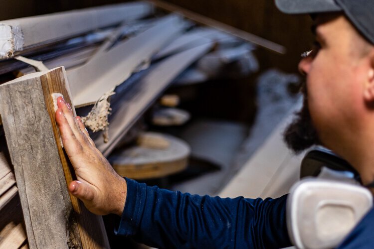 Mid Michigan Wood Works Owner Aaron Johnston demonstrates a how he applies the first of his five coats of varnish.