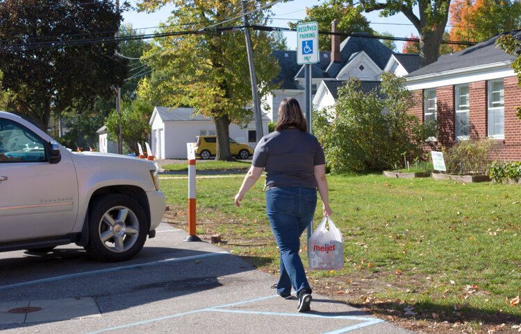 Veterans Memorial Library employee Jaclyn "Jackie" Prout brings out a customer's order to their vehicle as part of their curbside service.