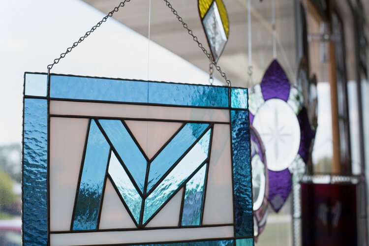 Stained glass art sporting Mid Michigan College's logo hangs in the window in Creatively! Glass & More.

"I got permission to use their logo and then design that panel for a graduation gift," says Holland. "There was a bit more interest besides just the customer that ordered it, so we have State, Central, Mid Michigan, and U of M panels that we try and keep available."