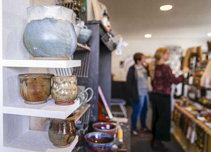 Ceramic creations by Central Michigan University student Sydney Belz and other CMU students sit on shelves awaiting purchase at All Things Divine. 