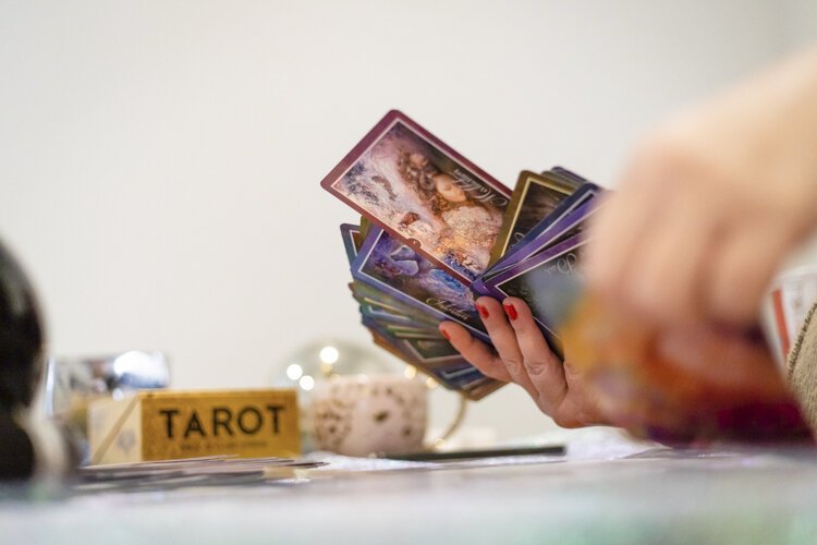 Jennifer Blizzard, tarot reader and psychic at All Things Divine, pulls a card from her deck as she reviews her tarot.