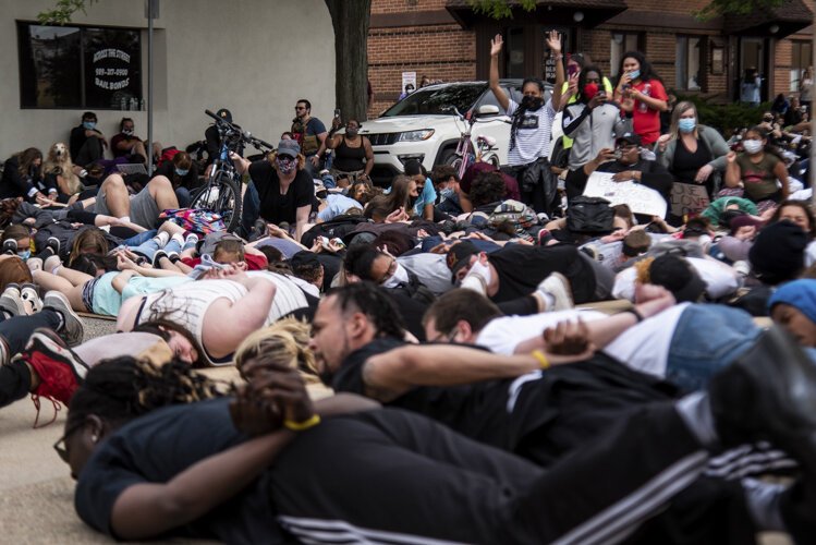 Protestors lie on the ground and chant, “I can’t breathe,” for nine minutes while others document during an event to protest the death of George Floyd and social injustice June 1 outside Isabella County Sheriff’s Office in Mt. Pleasant, MI.