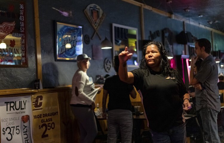 Mt. Pleasant resident Sheridan Pelcher takes her turn as part of a weekly darts tournament at Marty’s Bar.