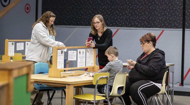 Alma College Head Start Program parent, Wendy Perrier, takes a photo of her son, Eli, making a paper rocket at the "Exploratorium" at the Mount Pleasant Discovery Museum.