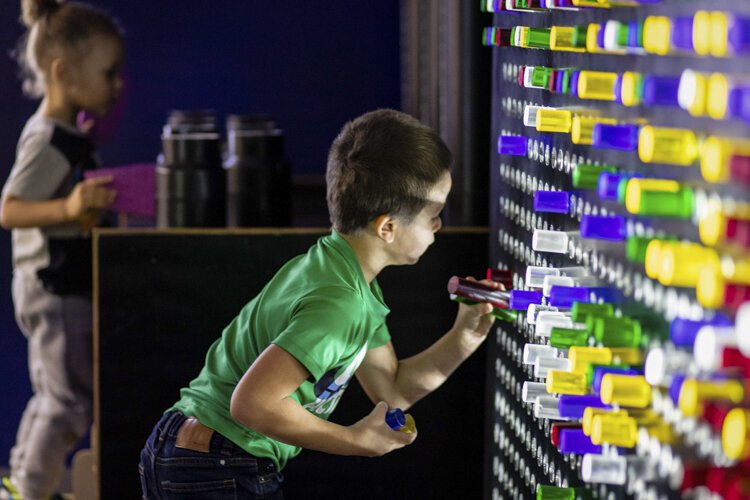 An Alma College Head Start Program preschooler interacts with an oversized Lite-Brite at the Mount Pleasant Discovery Museum.