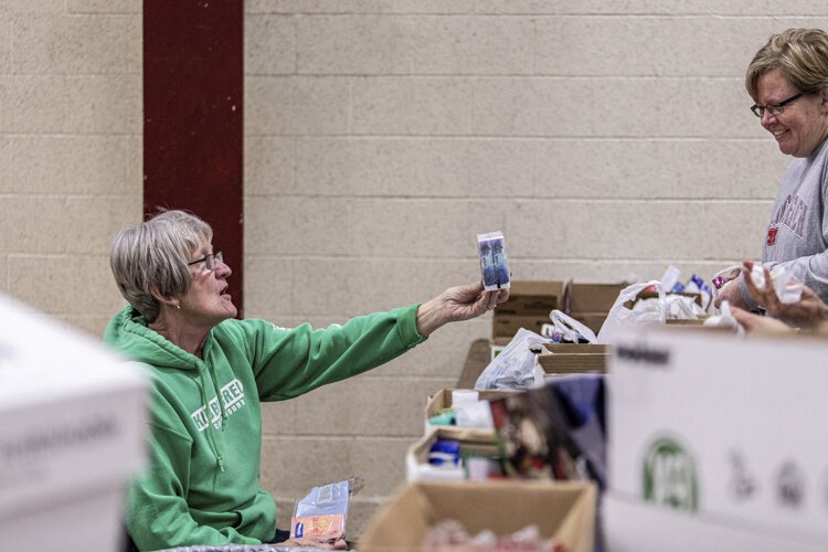 Shepherd resident Jan Heatherington, 70, and Mount Pleasant resident Claire DiMaria, 47, organize toiletries for adult stockings Dec. 3 at Finch Fieldhouse on Central Michigan University's campus. "It's well worth it," Heatherington says.