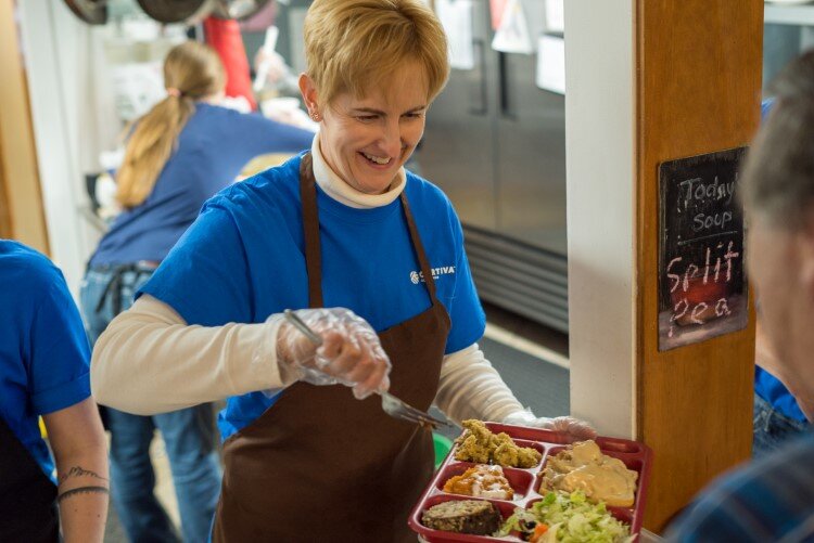 A volunteer serves up lunch in Open Door's soup kitchen.