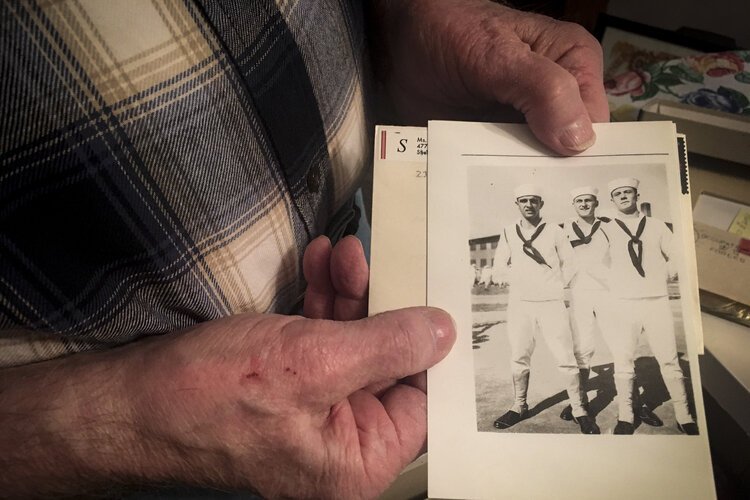 Henry Meabrod Sr. shows a photo of himself (middle) and two friends during his service in the Navy in WWII.