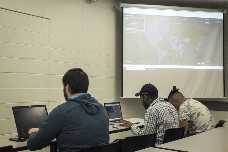 From left to right: Quintin Burgess, Andrew Anoruo, and Daymion Alzarez participate in a digital game of capture the flag at Central Michigan University on Oct. 11.