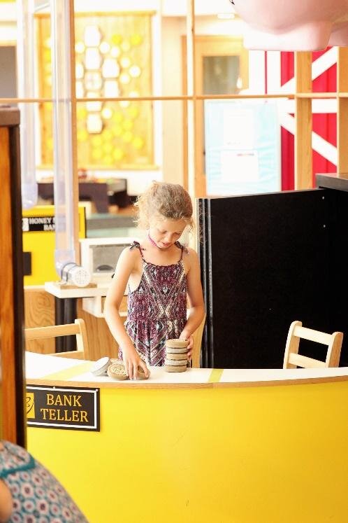 A young girl plays at the Honey Money Bank at the Mount Pleasant Discovery Museum.