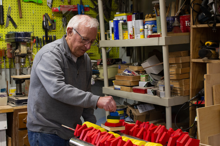 Don Hire demostrates a stacked block toy in his woodshop. Hire will craft as many as 80 stacking block sets for charity this year.