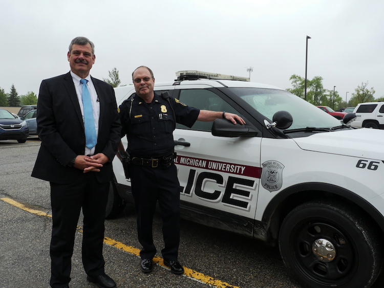 Central Michigan University Chief of Police Bill Yeagley and Lt. Larry Klaus, who will take over as Chief of Police, stand next to a CMU Police Department vehicle.