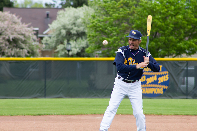 Luke Epple Sr., Head Coach of the Mount Pleasant High School Varsity Baseball Team, hits a baseball during team warmups before their game against Arthur Hill High School on May 20, 2019.