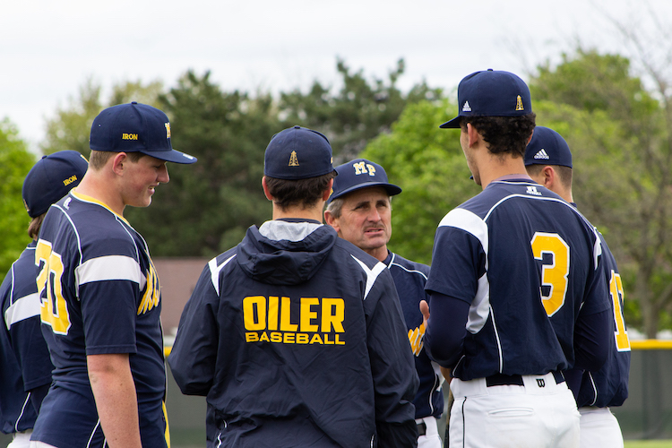 Luke Epple Sr., Head Coach of the Mount Pleasant High School Varsity Baseball Team, talks with members of his team before their game against Arthur Hill High School on May 20, 2019.