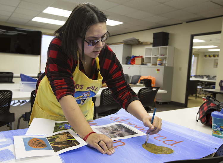 Chyann Haas works on her banner during class at the Saginaw Chippewa Tribal College on Tuesday, March 26, 2019.