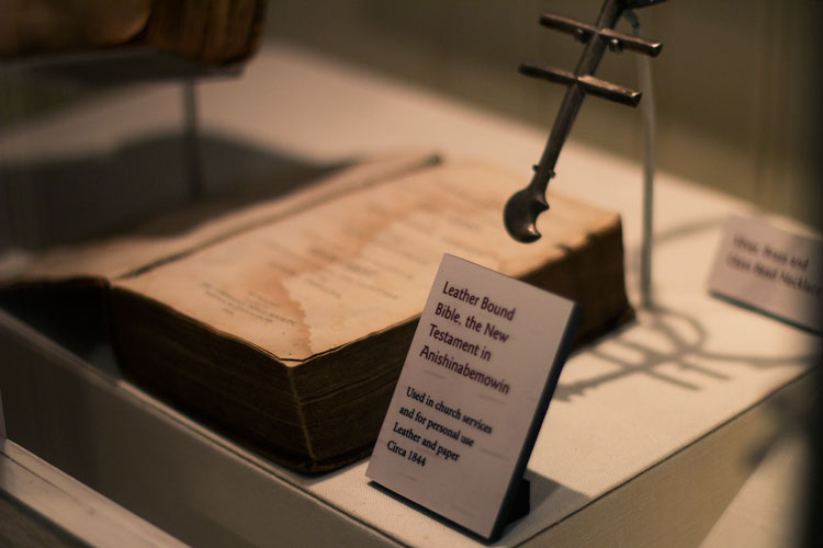 An exhibit on religion during colonization features bibles printed in the native language of many Great Lakes Indians