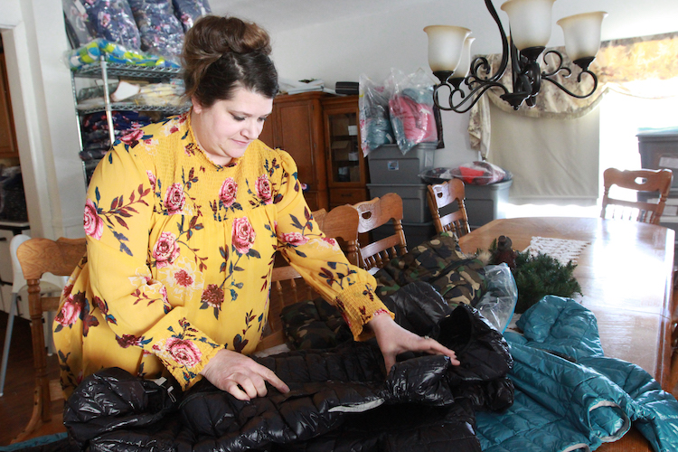 Jennifer Harrison, founder of X-Ability, unfolds a child size bodycoat on the table in the family dining room.