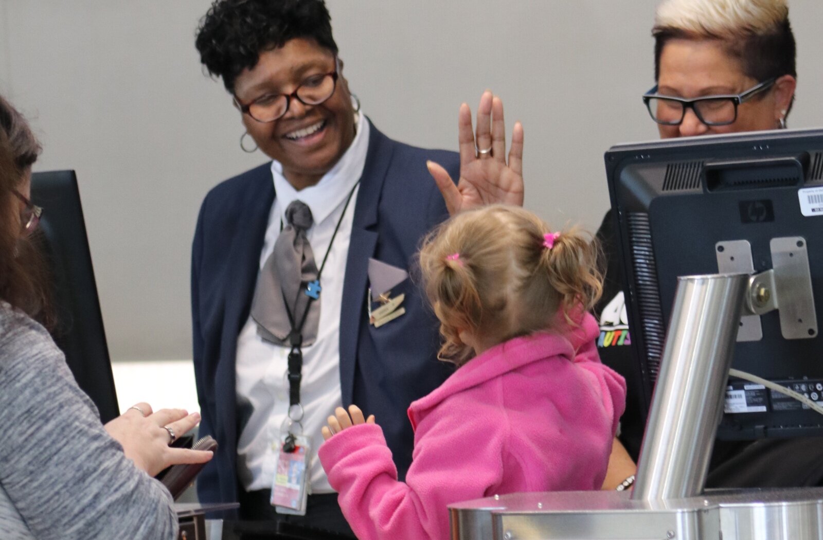 Volunteers guide participants through the terminal ticket desk, luggage check, and TSA.