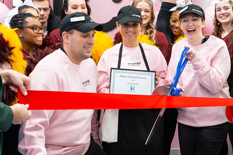 Mt. Pleasant Crumbl Cookies co-owners Cristin Gougeon, Michelle Jackson, and Todd Korneoely prepare to cut the ribbon at the grand opening event on Friday, Jan. 27, 2023. (Photo: Addy Wachter/Epicenter)
